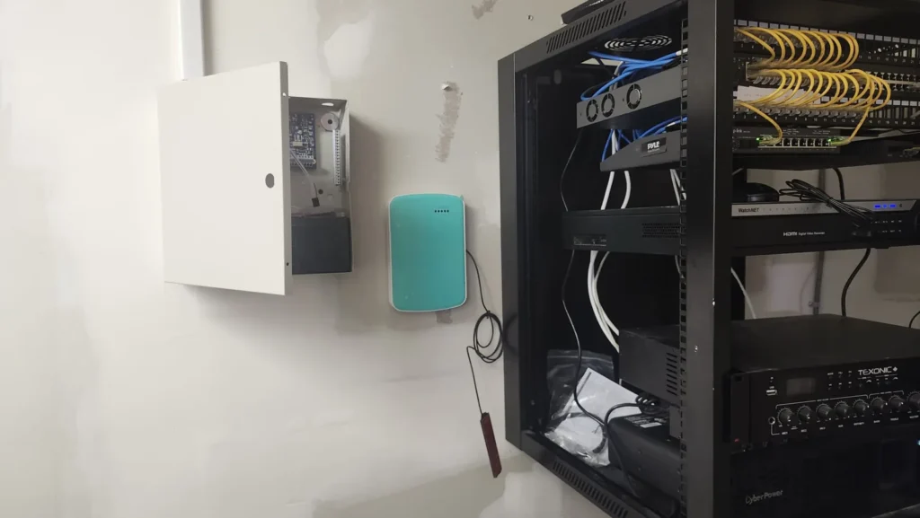 Alarm panel and communicator mounted beside the network rack