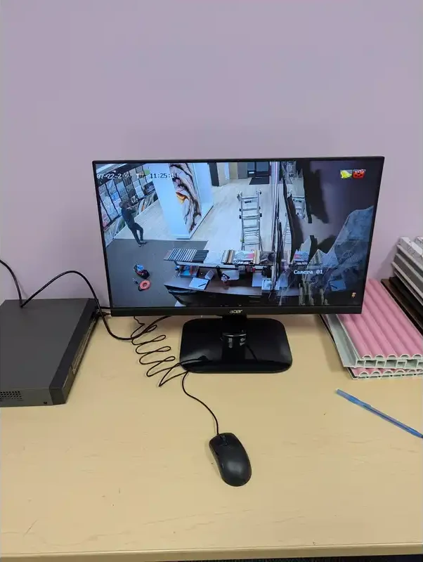 Monitor showing live CCTV camera feeds with the recorder on the desk