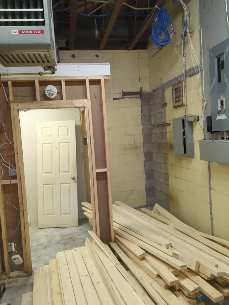 Network cabling run through open wall framing during a store fit-out, before drywall