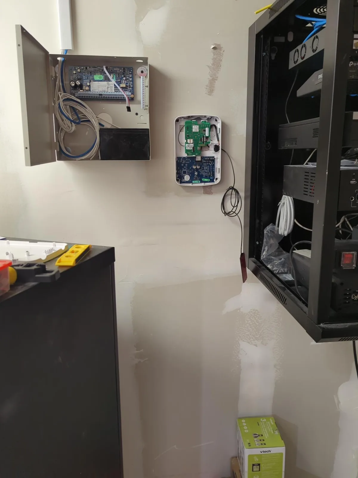 Wall-mounted network rack and alarm panel installed side by side in a new retail store